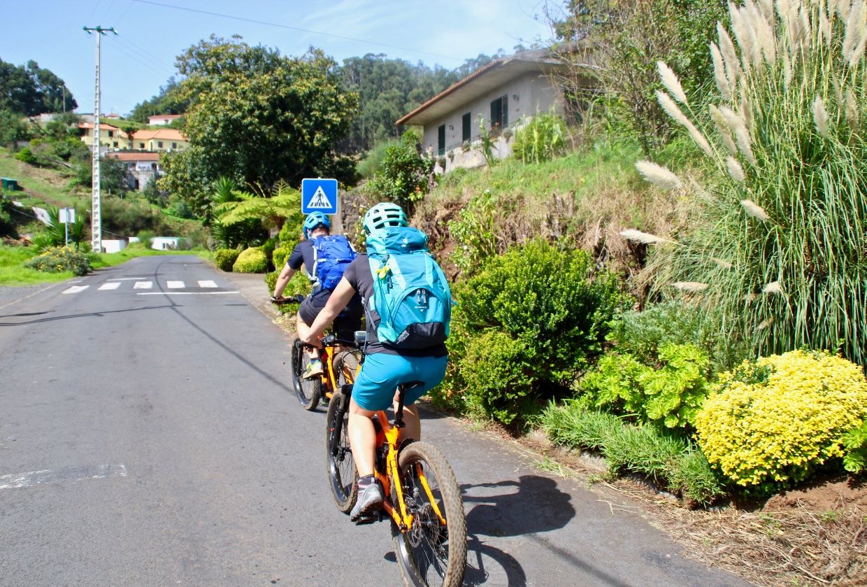 E-Biker radeln durch ein Dorf